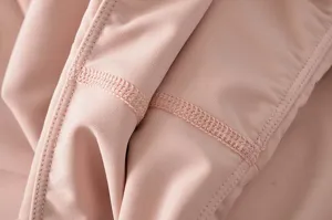 Detailopname van roze yogabroek met zachte, elastische stof en nette dubbele stiksels.