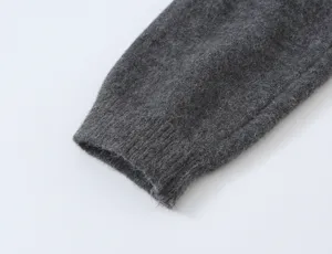 Dark grey knit sweater sleeve cuff detail close-up shot showing soft fabric texture.