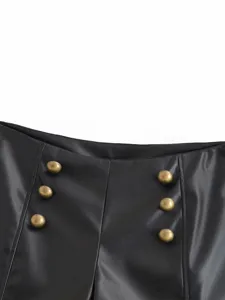 Close-up of women's black faux leather shorts waist with metallic gold double-breasted buttons.