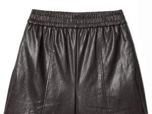 Close-up detail of womens high waist faux leather shorts waistband showing texture and seams.