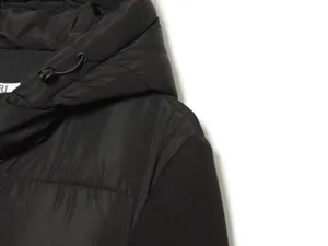 Dettaglio giacca imbottita nera, capo invernale caldo con tessuto di alta qualità e cuciture.