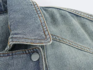 Close up detailweergave van de blauwe dames denim jas kraag met contraststiksels en knop.