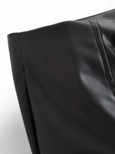 Detailed view of stylish black faux leather shorts showcasing fine texture and neat stitching.
