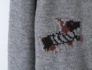 Close-up detail of grey knit cardigan featuring a cute dog intarsia knit pattern.