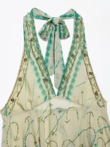 Close up of the green tie-dye halter neck top featuring sparkling sequin embroidery details.