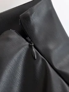 Black faux leather high waist shorts detail, stylish European style clothing close up.
