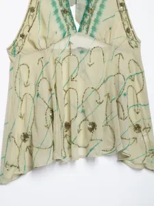 Detail shot of halter neck open-back top with green tie-dye and gold sequin embroidery.