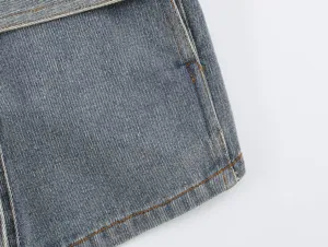 Close-up detail van spijkerjack met klassieke blauwe wassing en oranje stiksels.