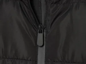 Primo piano dettagliato della cerniera di una giacca invernale nera, tessuto premium.