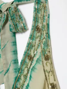 Detailed view of women's halter top strap featuring green tie dye print with sequin embroidery.