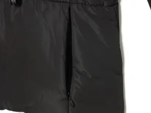 Primo piano dettagliato della tasca di una giacca nera imbottita con pratica zip.