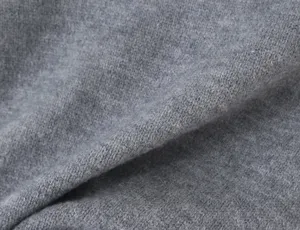 Close-up shot showing the fine texture and soft knit fabric of the stylish gray apparel piece.