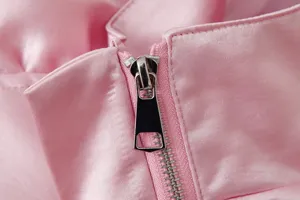 Rosa Jackendetail, Nahaufnahme des metallisch silbernen Reißverschlusses und Stehkragens.