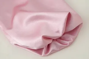 Rosa Satin Stoff Detailaufnahme mit glatter Textur, schönem Fall und weichem Glanz.