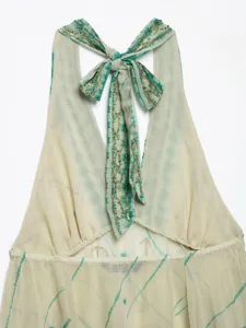 Detail view of a halter neck backless top with tie-dye print and sequin bead embroidery.