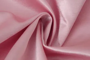 Nahaufnahme des glatten rosa Satinstoffes zeigt feine Textur und natürliche Drapierung.