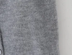 Grey knit fabric detail texture close-up shot showing soft wool material and fine stitch design.