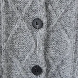 Grijze kabelgebreide vest trui met knopen close-up textuur detail casual top voor dames