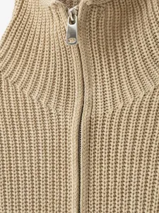 Nahaufnahme der Textur des khakifarbenen Rippstrick-Cardigans mit Reißverschluss.