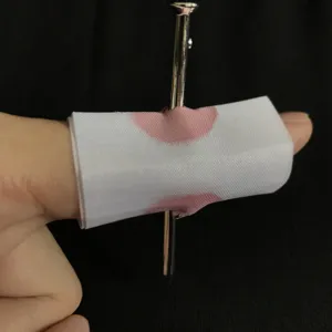 Primo piano del finto chiodo attraverso il dito oggetto di scherzo dal design realistico.