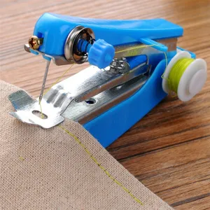 Closeup of handheld manual mini sewing machine stitching beige fabric detail on wooden table.