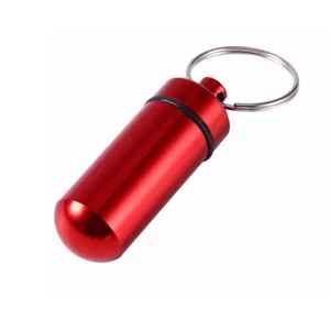 Red aluminum alloy pill bottle keychain detail, portable waterproof container close up view.