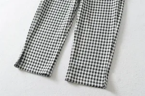 Detailed shot of women's black and white gingham capri pants with stylish side slits.