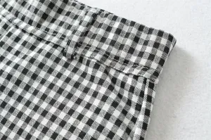 Close-up detail of classic black and white gingham pants waistband and belt loops texture.