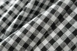Detailed close-up view of black and white checkered knit fabric with soft texture.