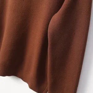 Close-up detail of soft brown knit fabric, showing fine texture and cozy autumn style.