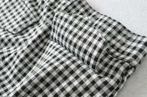 Close-up detail of black and white plaid fabric showing pocket texture and classic pattern.