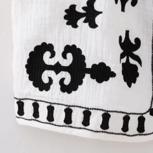 Black and white embroidered vest main view showing delicate traditional patterned fabric details.