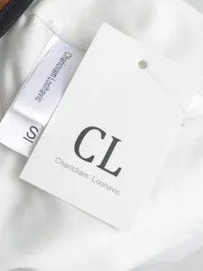 Close-up detail shot of clothing hangtag and size label showing brand and size information.