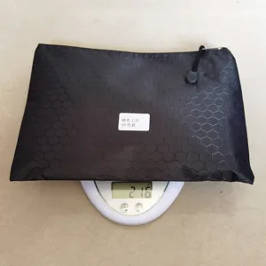 Vue détaillée de la pochette de rangement noire hexagonale affichant le poids sur balance.