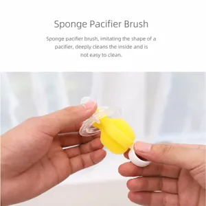 Sponge pacifier brush detail showing soft yellow foam head and clear handle for cleaning baby nipples.