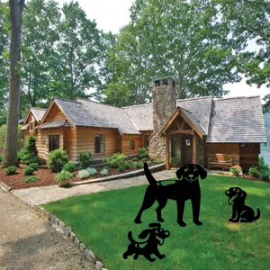 Detail view of black acrylic dog silhouette stakes displayed on green lawn in garden setup.