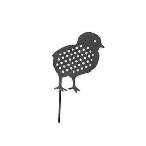 Close-up detail of the black metal chick garden stake with hollow-out polka dot design.