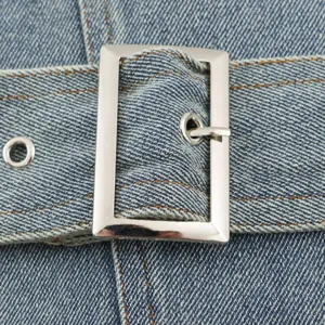 Detail riemgesp spijkerjasje voor dames, stijlvolle blauwe denim jas met metalen hardware.