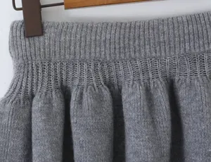 Grey knit skirt detail close-up showing elastic waistband and fluffy pleated texture.
