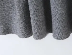 Grey pleated knit skirt detail close-up, soft texture fabric macro shot texture view.