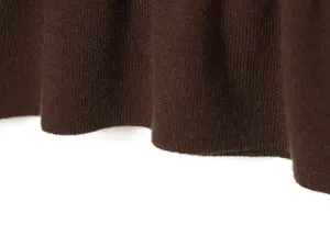 Detailed view of women's brown knit top hem, showing fine fabric texture and soft folds.