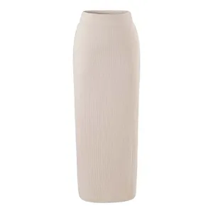 Beige knitted ribbed high-waist maxi skirt detail, elastic waistband texture close-up.