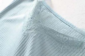 Close-up detail of light blue ribbed knit fabric featuring elegant lace trim design.