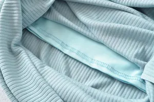 Close-up detail of light blue ribbed knit garment lining and neat stitching craftsmanship.