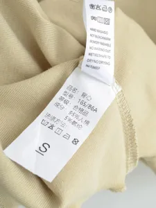 Nahaufnahme der weichen, gerippten Tanktop-Stoffstruktur und des Waschetiketts.
