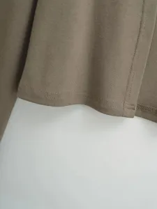 Nahaufnahme im Detail zeigt die saubere Naht und den Saum des einfarbigen Langarmtops.