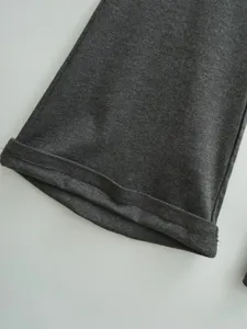 Dunkelgraue Kleidung Saum Detail Nahaufnahme, feiner Strick Stoff Naht Textur Produktfoto.