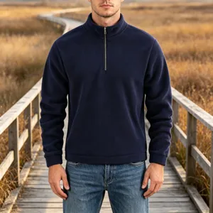 Detailed view of men's half-zip fleece sweatshirt worn on wooden boardwalk in outdoor setting.