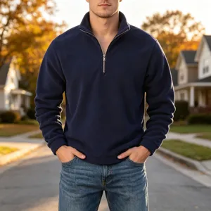 Close-up detail of a dark blue men's half-zip fleece pullover with a stand collar outdoors.
