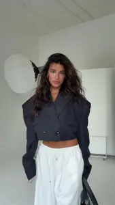 Vista di dettaglio dell'elegante blazer corto nero da donna con spalline esagerate.